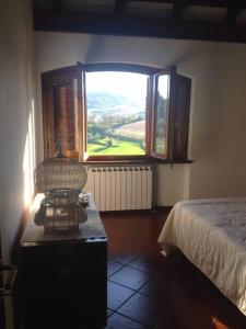 een slaapkamer met een bed en een groot raam bij Charming Villa in Monferrato in Camino