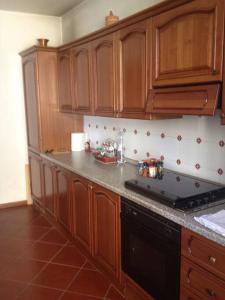 cocina con armarios de madera y horno con fogones en Charming Villa in Monferrato, en Camino