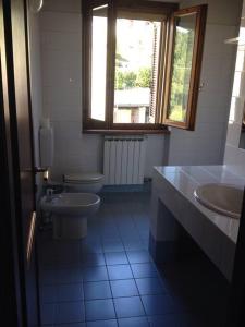 baño con 2 lavabos, aseo y ventana en Charming Villa in Monferrato, en Camino