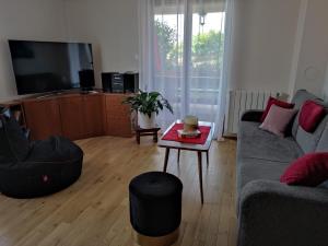 uma sala de estar com um sofá e uma mesa em Apartman Roža em Matulji