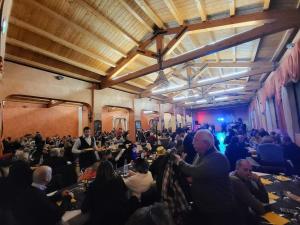 een grote groep mensen die aan een tafel in een kamer zitten bij alloggio greenpark in Milazzo