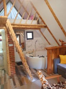 uma casa de banho com banheira num sótão em Etno selo BISTROVO em Vitez