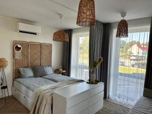 a bedroom with a bed and a large window at Nida, Vėtrungių 7 apartamentai prie marių in Nida