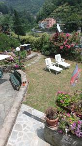 a yard with two chairs and a flag and flowers at Casa Ylenia in Borzonasca