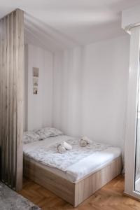 a white bedroom with a bed in a room at Apartman Vas dom 2 in Kraljevo