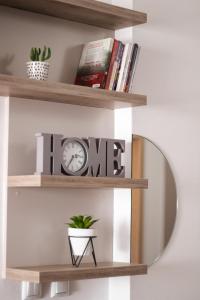 a circular shelf with a clock and a mirror at Apartman Vas dom 2 in Kraljevo