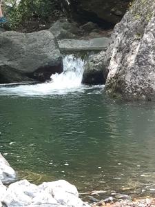 una pequeña cascada en un río con rocas en Casa Ylenia en Borzonasca