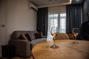two glasses of wine sitting on a table in a living room at Bozur/peony in Pasuljište