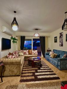 a living room with two couches and a table at Telal Al Sukhna Only families in Ain Sokhna