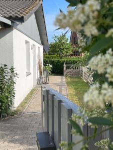 einen Zaun vor einem Haus mit Auffahrt in der Unterkunft Strandzone 29 in Kronsgaard