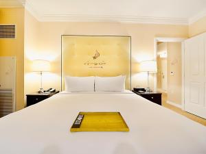 Una cama blanca grande con una bandeja de madera. en Amalz Suites Collection at MGM Signature ! en Las Vegas