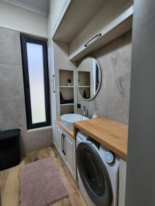 ein Badezimmer mit einer Waschmaschine und einem Waschbecken in der Unterkunft Cozy PineTrees Beach House in Golem