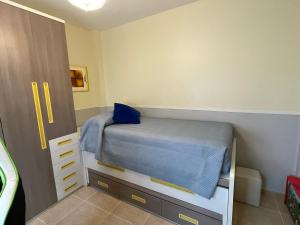 a small bedroom with a bed and a cabinet at Esencias Azahar in Chiclana de la Frontera