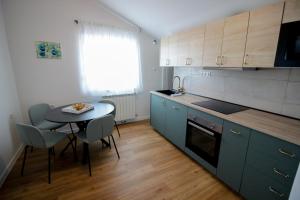 uma cozinha com uma pequena mesa, uma mesa e cadeiras em Apartment Castelmuschio em Omišalj