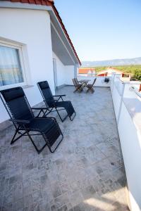 a patio with two chairs on a roof at Apartment Castelmuschio in Omišalj