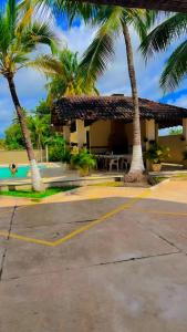 a house with palm trees and a yellow parking lot at Salinas AzulGávea in Salinópolis
