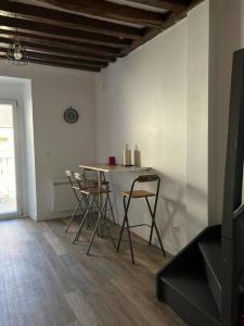 a dining room with a table and chairs in a room at Appartement plein de charme in Coignières