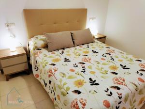 um quarto com uma cama com colcha floral em Castle View em Santa Pola