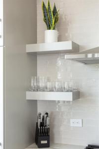 a kitchen with shelves and a plant on the wall at 'Cloud 10' A Luxury Downtown Condo with Panoramic City and Mountain Views at Arras Vacation Rentals in Asheville