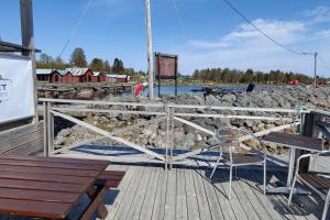 a wooden deck with a bench and a fence at Gästhus nära naturen in Holmsund