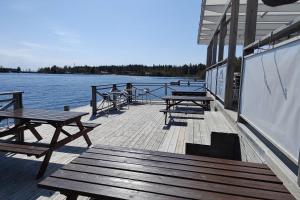 a dock with benches and tables on a boat at Gästhus nära naturen in Holmsund