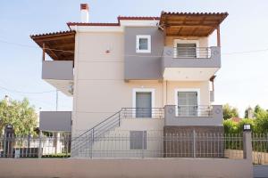 a white house with a fence in front of it at Electra Maisonette with Garden near Sea in Kamárai
