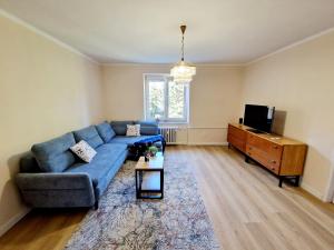 a living room with a blue couch and a tv at City Center Apartment - Self check-in in Spišská Nová Ves