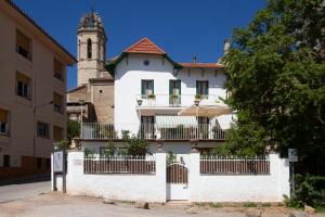 a white house with a balcony and a tower at Bell Plançó B&B in Moià