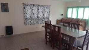 a dining room with a table and chairs and a couch at Lujan de Cuyo Mendoza in Ciudad Lujan de Cuyo +4 photos