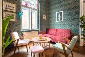 een woonkamer met een rode bank en een tafel bij Das Hostel in Krakau