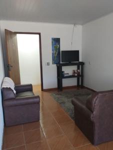 因比圖巴的住宿－POUSADA DA PONTE IBIRAQUERA，客厅配有两张沙发和一台电视