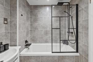uma casa de banho com um chuveiro e uma banheira em The Riverside Rest em Stirling