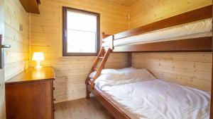 a bedroom with two bunk beds in a wooden cabin at Sielankowe Domki in Rusinowo
