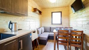 a living room with a couch and a table and chairs at Sielankowe Domki in Rusinowo