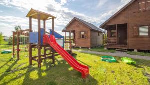 a playground with a slide and a house at Sielankowe Domki in Rusinowo