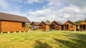 a row of houses with a playground in the yard at Sielankowe Domki in Rusinowo