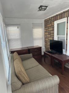 a living room with a couch and a television at Shore Beach Houses - 43A Lincoln Ave in Seaside Heights