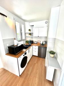 a kitchen with white cabinets and a stove top oven at Enghien T2 Coeur de ville 12 mn de Paris in Enghien-les-Bains
