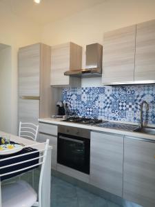 a kitchen with blue and white tiles on the wall at Villa Furoris Apartment in Furore
