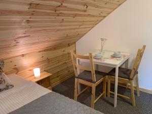 a room with a table and two chairs and a bed at Modrzewiowe Zacisze in Chocieszow