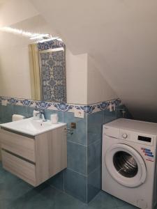 a bathroom with a washing machine and a sink at Villa Furoris Apartment in Furore