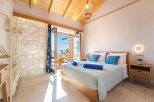 a bedroom with a large bed with blue pillows at Pithari Stone Villa in Khalikerí +20 photos