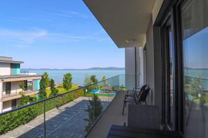 a balcony of a house with a view of the water at Platán Beach Apartman in Balatonboglár