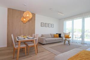 uma sala de estar com uma mesa e um sofá em Platán Beach Apartman em Balatonboglár