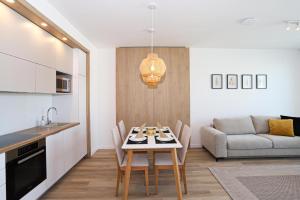 a kitchen and living room with a table and a couch at Platán Beach Apartman in Balatonboglár