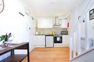 a kitchen with white cabinets and a wooden table at Central Buckingham Apartment #5 with Free Parking, Pool Table, Fast Wifi and Smart TV with Netflix by Yoko Property in Buckingham