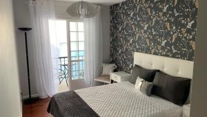 1 dormitorio con 1 cama con pared estampada en blanco y negro en Casa da Alfóndega, en Caldas de Reis