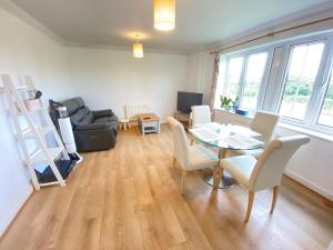 a living room with a table and chairs and a couch at Sweet home 2 Double bedrooms apartment free parking Summertown, Oxford in Oxford