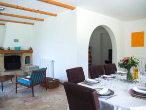 a dining room with a table and chairs and a fireplace at Mas Grenadine, magnifique villa du Piémont Cévenol in Sauve