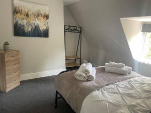 - une chambre avec un lit et des serviettes dans l'établissement Oak House - 3bed Townhouse with free parking by ShortStays4U, à King's Lynn